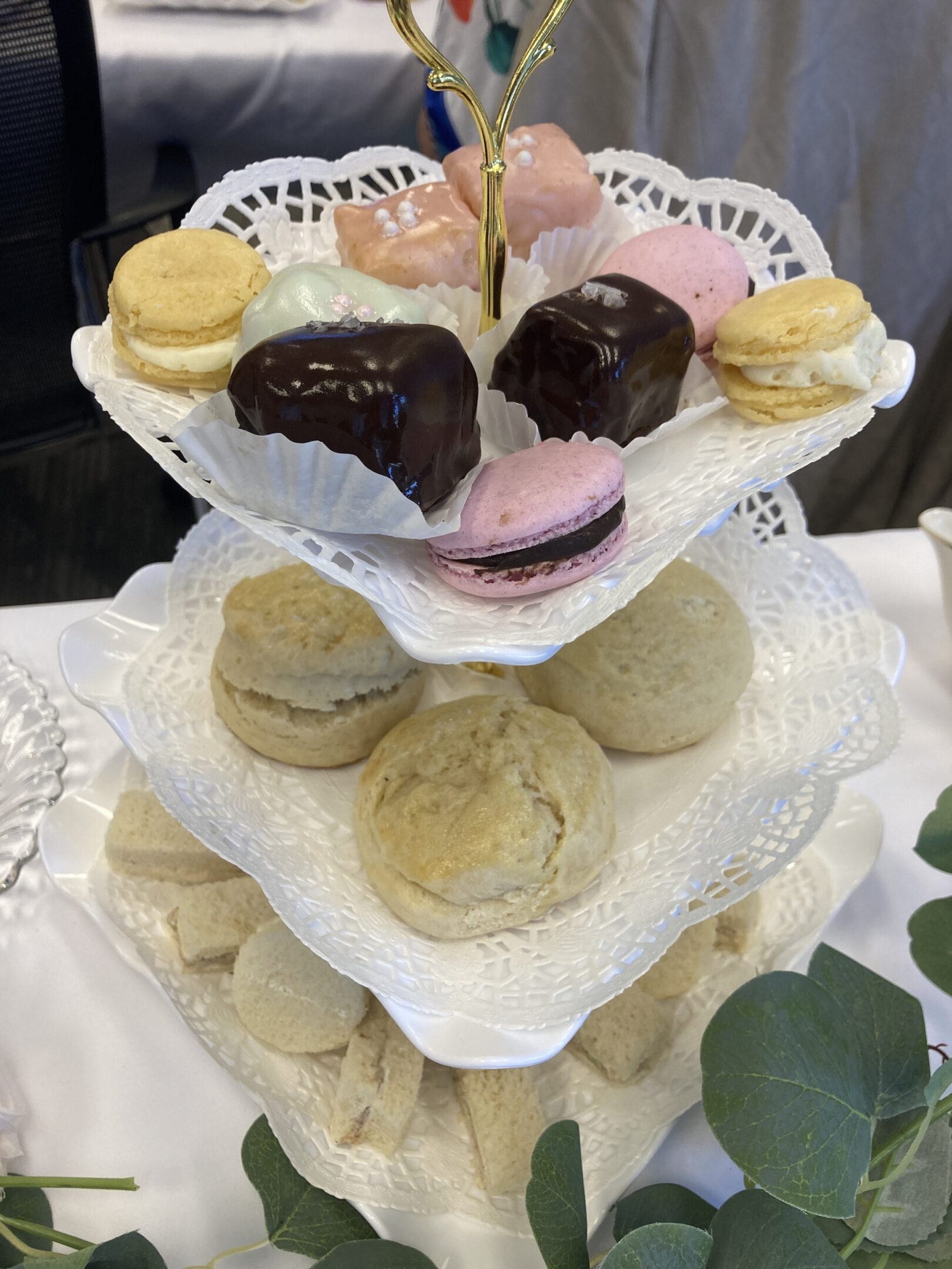 A tiered stand with assorted colorful macarons and cookies.