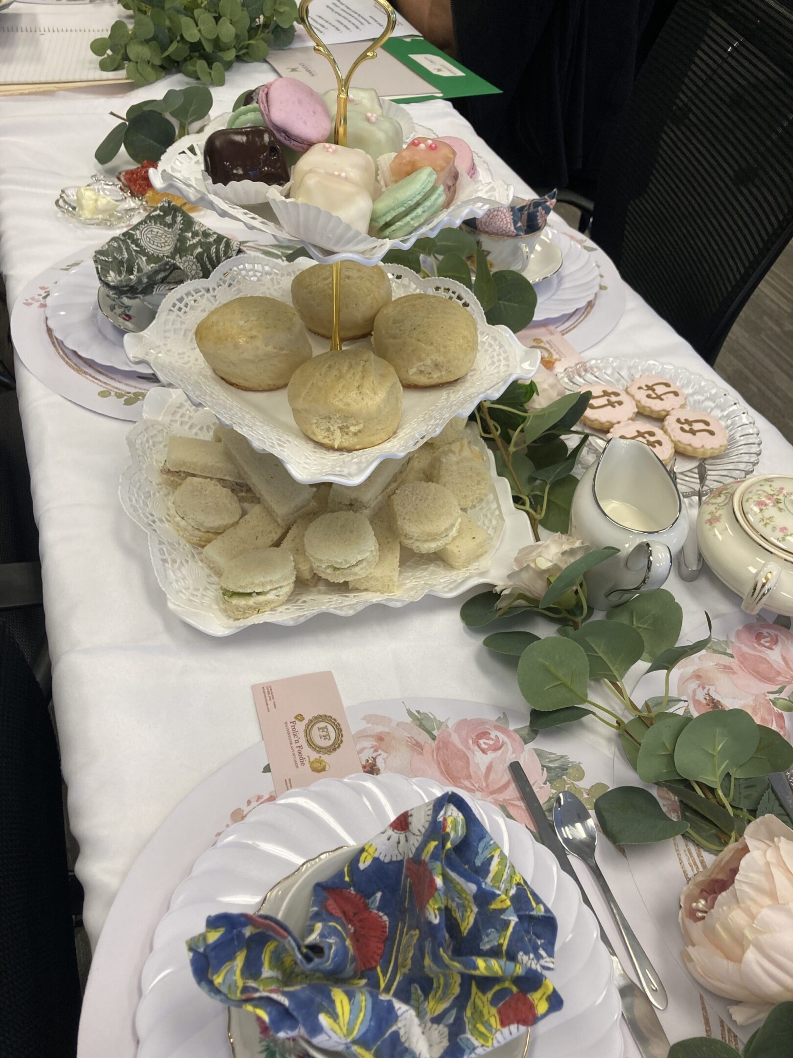 A tiered tray with bread rolls and dumplings on a decorated table.